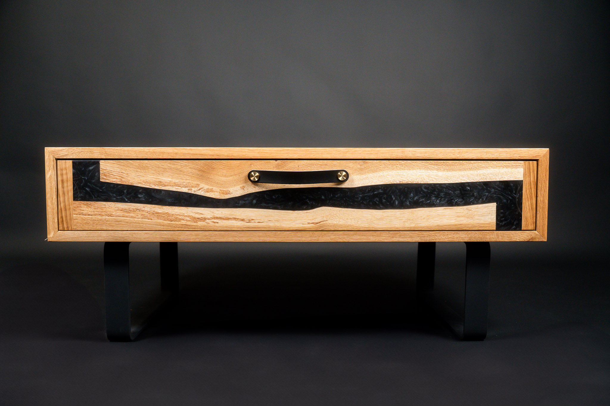Table basse chêne et résine noire vue de face avec poignée en cuir et laiton